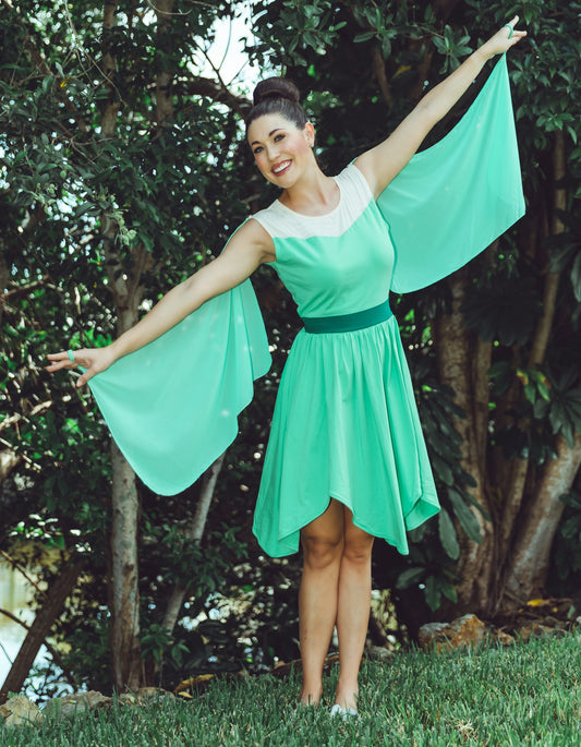 Woman wearing adult Tinkerbell-inspired green fairy dress with flowing winged sleeves, standing outdoors with arms outstretched

Adult green fairy costume dress with white neckline, flowy wing sleeves, and flared skirt, styled in a magical outdoor setting

Green fairy cosplay dress for women featuring chiffon-style wings and fantasy-inspired silhouette, perfect for Tinkerbell look