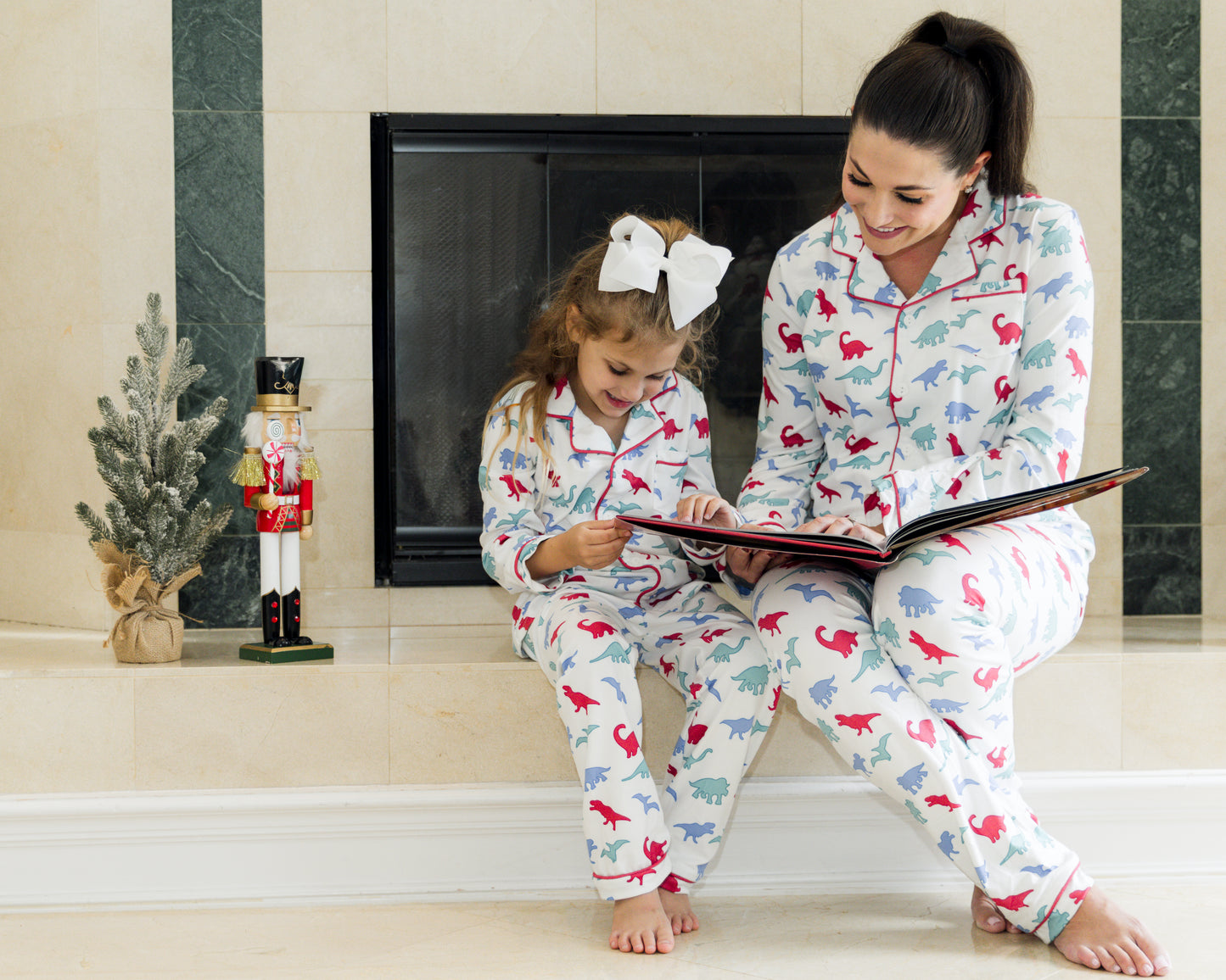 Mom and daughter wearing matching dinosaur pajamas in red, blue, and green print, cuddling and smiling in cozy indoor setting

Matching mommy and me dinosaur pajama set with colorful dino print, perfect for bedtime, holidays, or family photos

Mother and child snuggling in coordinating white dinosaur print pajamas with red piping, styled for cozy family moments