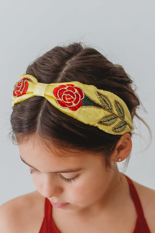 Our Red Rose Princess Headband is comfortable and designed for all day wear.  The yellow satin has a red rose embroidered on each side.  The rose, stem and leaves have beaded gold details. 