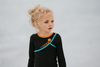 A young girl is wearing a 2 piece long sleeve rash guard swim set. The top is black with turquoise and goldenrod accents. The bottom has a turquoise ruffle over a mint teal skirt with goldenrod hem accent. 