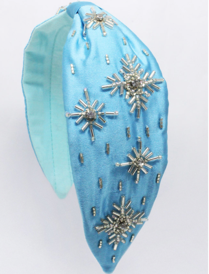 Our Snowflake Sparkle Headband is comfortable and designed for all day wear.  The wide satin fabric is bright blue. It is adorned with crystal beads sewn in the shapes of snowflakes.  This is a perfect accessory for and Ice Queen or Princess. 