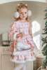 A young girl is wearing a long sleeve pink twirl dress adorned with white and silver ice skates.  The sleeves and hem of the twirl are lined with white faux fur.  There is a double layer skirt for excellent twirling.  Also included is a white faux fur hand muff with pink bow. 