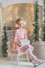 A young girl is wearing a long sleeve pink twirl dress adorned with white and silver ice skates.  The sleeves and hem of the twirl are lined with white faux fur.  There is a double layer skirt for excellent twirling.  Also included is a white faux fur hand muff with pink bow. 