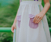 A young girl wears a sporty space hero twirl dress.  The cotton dress is sleeveless and has light green panels on the bodice with embroidered button like features.  There are light green and light purple racing stripes down the side. The front has two pockets on the skirt. 