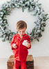 A young child is dressed in the buttery soft Unisex Pj's in Red from our Christmas Lounge Collection. The true Christmas red pajamas have a classic design.  They are piped with white trim.  The 2 piece pj set is perfect for photos and warm cozy holiday cheer. 