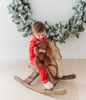 A young child is dressed in the buttery soft Unisex Pj's in Red from our Christmas Lounge Collection. The true Christmas red pajamas have a classic design.  They are piped with white trim.  The 2 piece pj set is perfect for photos and warm cozy holiday cheer. 