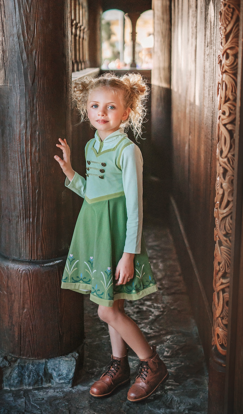 For the first time in forever....a long sleeve cotton twirl dress in spring greens.  The bodice is adorned with 6 buttons and iridescent ribbon. There is a faux vest look and the skirt is a bright earthy green with floral pattern on the hem. Perfect for getting out of the castle. 