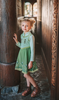 For the first time in forever....a long sleeve cotton twirl dress in spring greens.  The bodice is adorned with 6 buttons and iridescent ribbon. There is a faux vest look and the skirt is a bright earthy green with floral pattern on the hem. Perfect for getting out of the castle. 