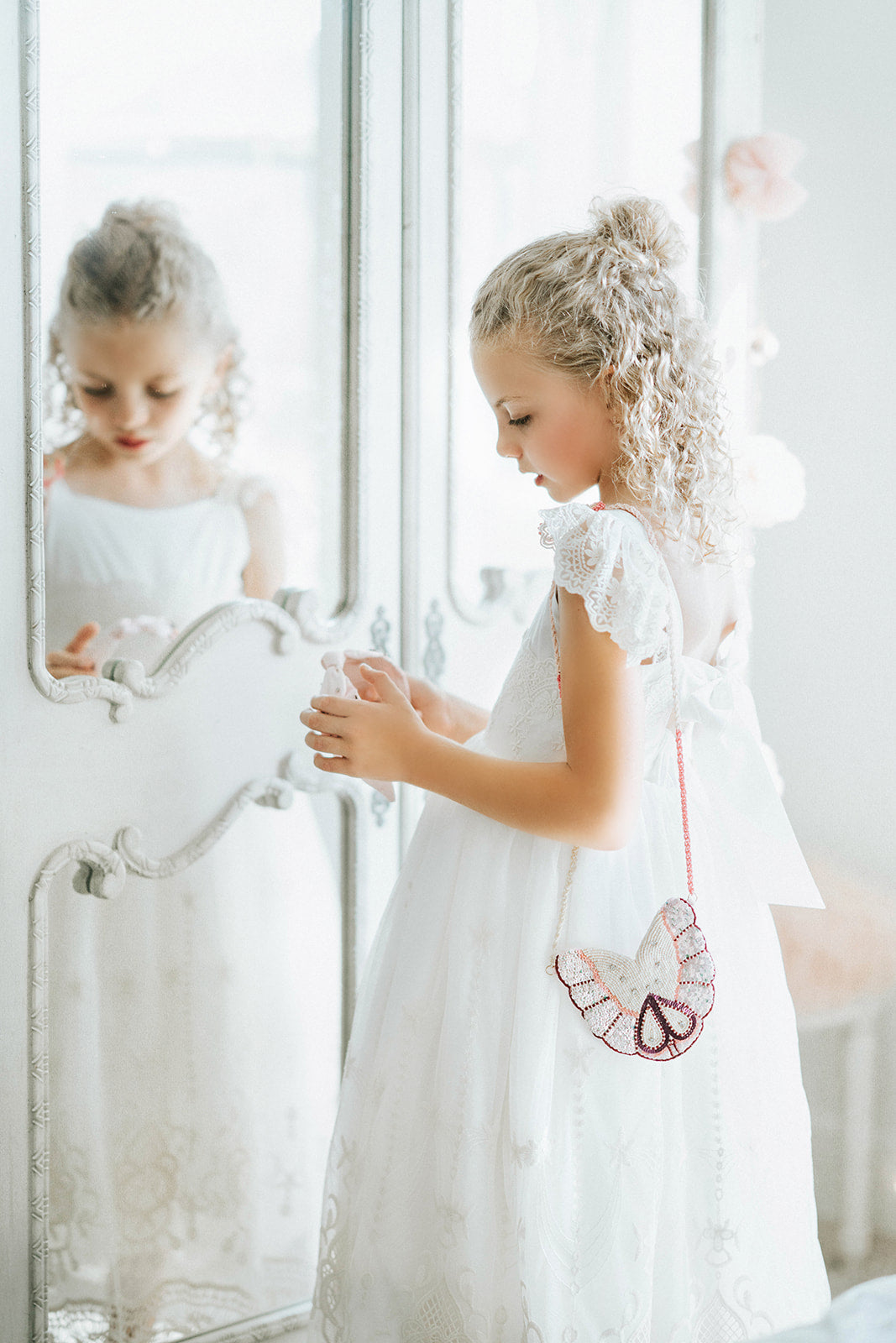 Pink butterfly headband for girls with pearl and sequin beading, held by child wearing a white lace dress

Beaded butterfly hair accessory in soft pink, ideal for girls' special occasions, portraits, or whimsical gifting