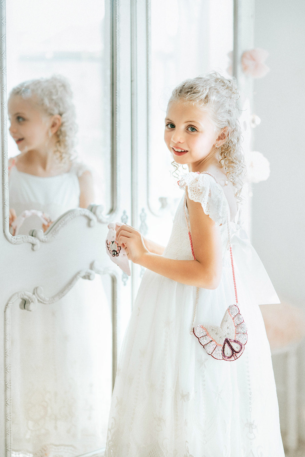 Pink butterfly headband for girls with pearl and sequin beading, held by child wearing a white lace dress

Beaded butterfly hair accessory in soft pink, ideal for girls' special occasions, portraits, or whimsical gifting