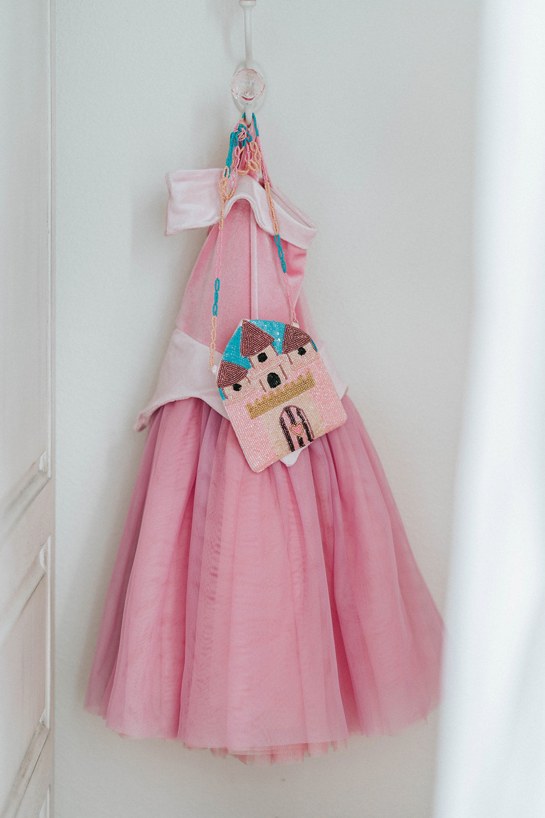 Hand-beaded pink castle purse with heart-shaped door and gold accents, ideal accessory for princess dress-up or gifting