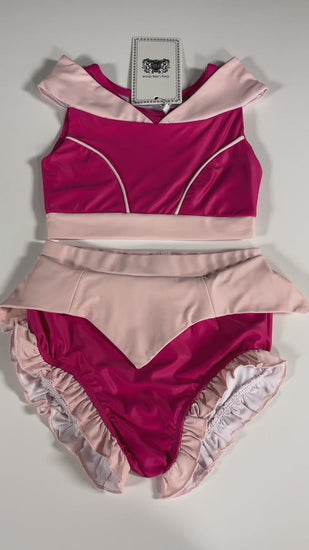  The Sleeping Beauty swim set has a pink collar that resembles a ballgown.  The top has light pink piping and trim.  The modest bottoms have a pink overlay and ruffles on the legs. 