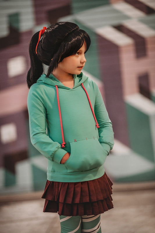 A child dressed up as a favorite movie character.  This perfect addition to any character collection includes a turquoise hoodie, brown pleated skirt, and green and white striped leggings.